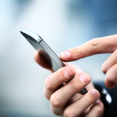 Close up of a man using mobile smart phone